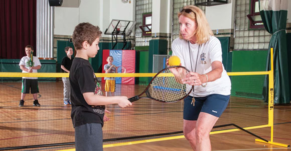 boy being taught tennis